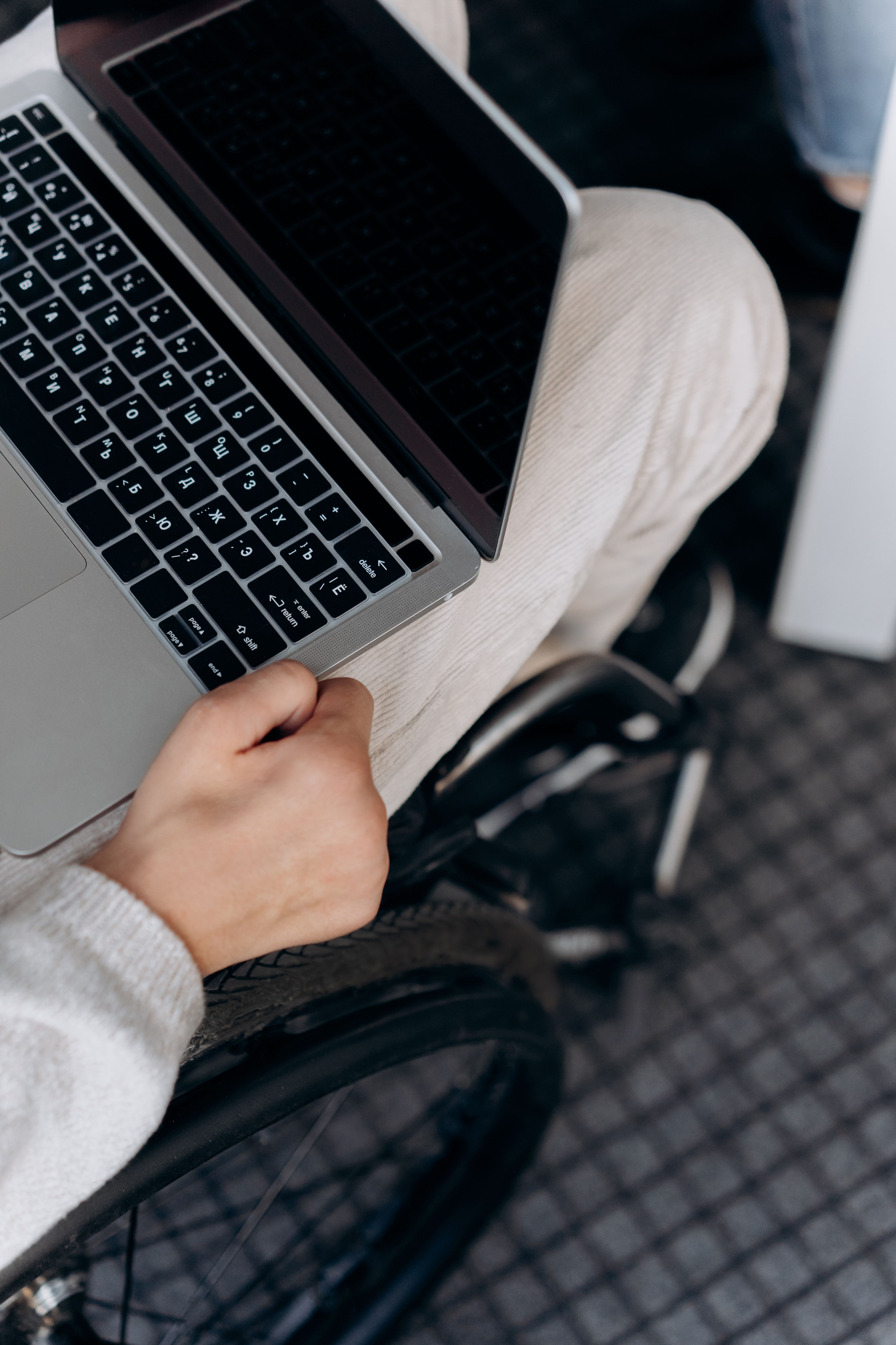 Une personne en fauteuil roulant utilise un ordinateur portable lors d'une formation au numérique.